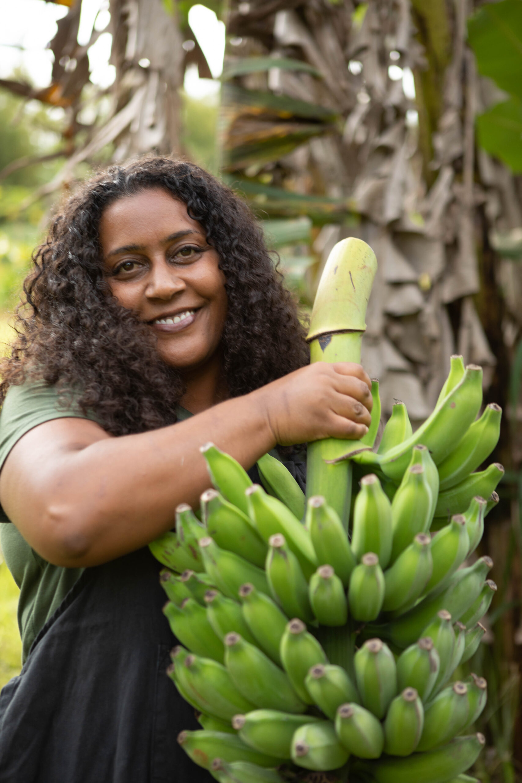Gida holding a just cut banana stalk