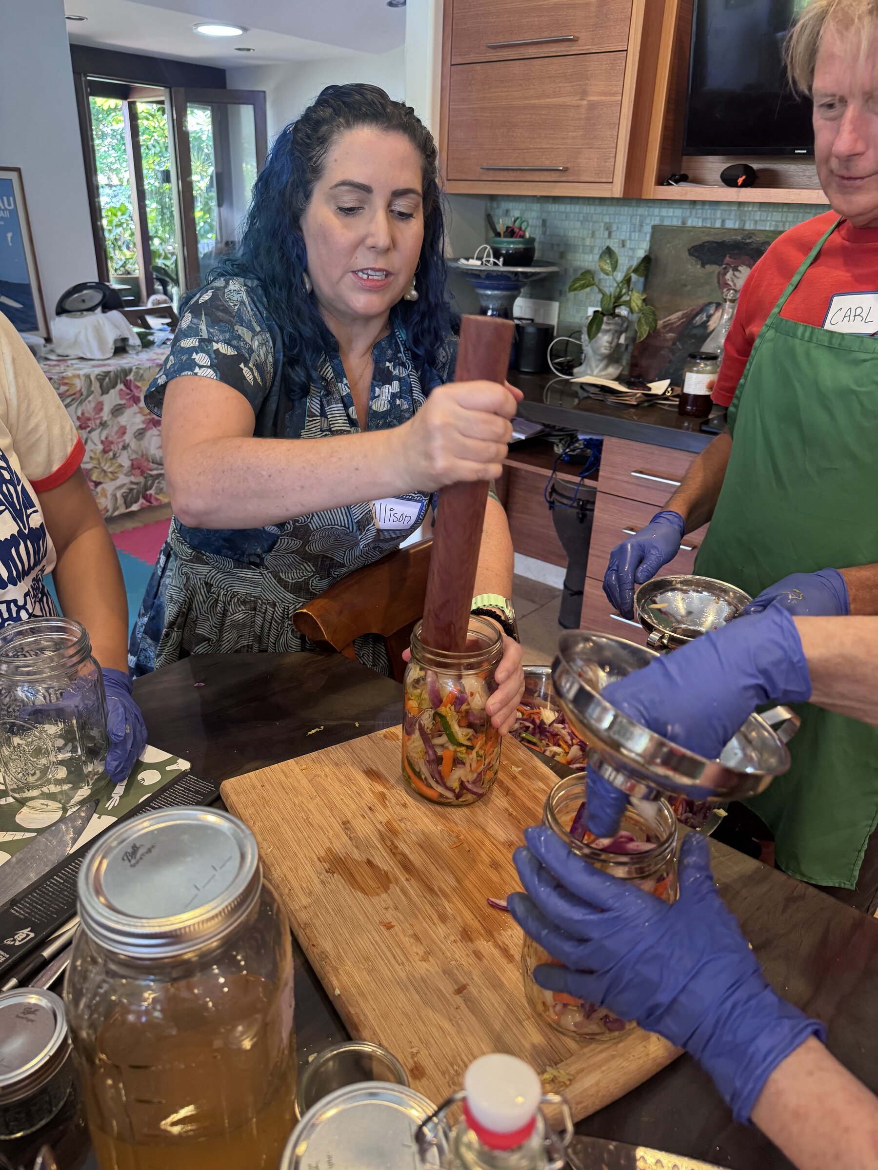 Allison Hardin pressing vegetables into a mason jar to make kimchi